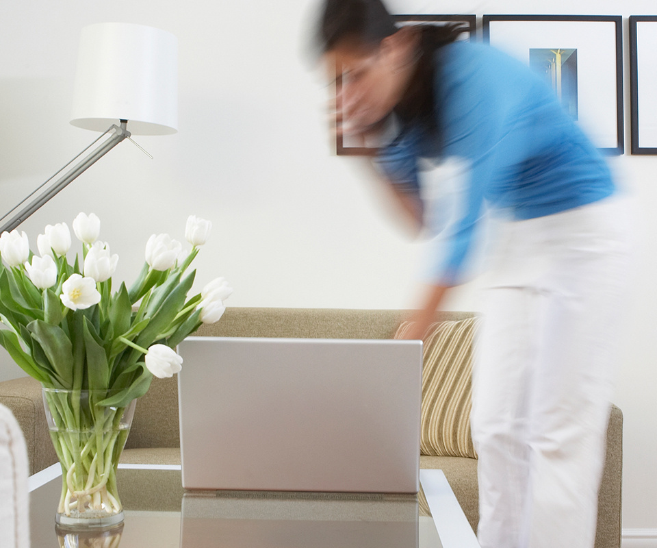 Woman walking to check something on her laptop while on the phone