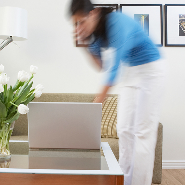 Woman walking to check something on her laptop while on the phone